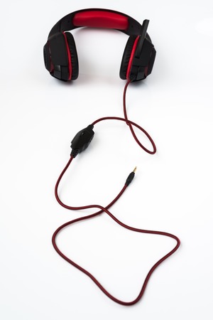 black gaming headphones with cord on a white backgroundの写真素材