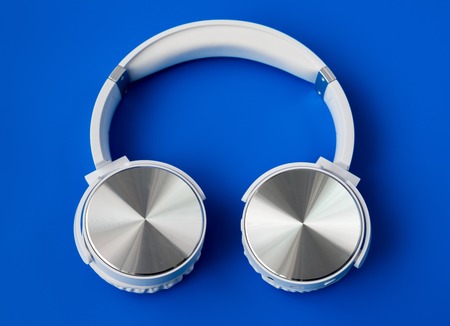 white wireless earphones on a blue backgroundの写真素材
