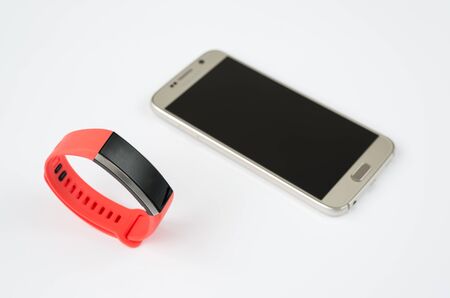 A fitness tracker and smartphone on a light backgroundの写真素材