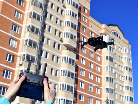 Quadrocopter flies in the sky and hands with a control panel.の写真素材