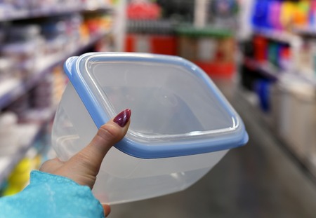 Plastic food container in female hand on shop backgroundの写真素材