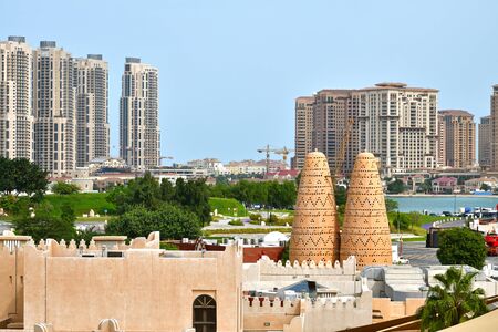 Doha, Qatar - Nov 23. 2019. Modern skyscrapers on Pearl Island and fragments of traditional architectureのeditorial素材