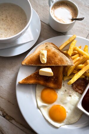 Fried eggs with toast and a french fries for breakfast