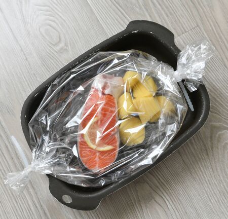 Raw trout and potatoes in baking filmの写真素材