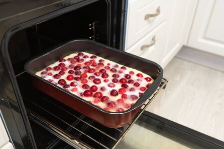 Raw cherry pie on baking sheet in the ovenの写真素材