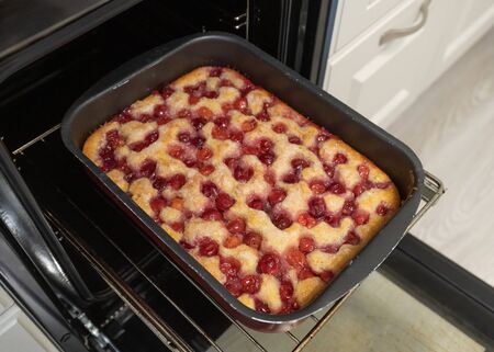 Baked cherry pie on baking sheet in the ovenの写真素材