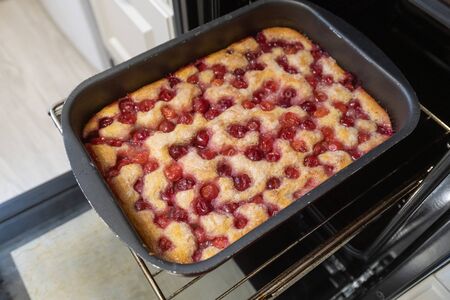 Baked cherry pie on baking sheet in the ovenの写真素材