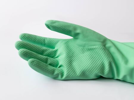 Green latex dishwashing gloves on white backgroundの写真素材