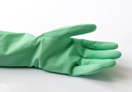 Green latex dishwashing gloves on white backgroundの写真素材