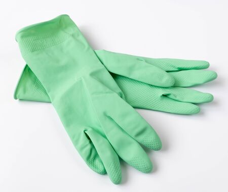 Green latex dishwashing gloves on white backgroundの写真素材