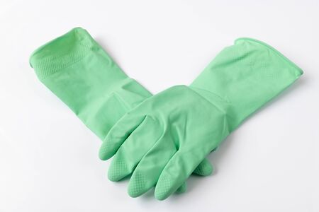 Green latex dishwashing gloves on white backgroundの写真素材