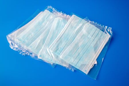 disposable new in packaging medical mask on blue backgroundの写真素材