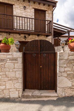Wooden gate and stone fence in front of the house in Cyprusの写真素材