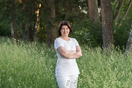 brunette woman near tree in summer parkの写真素材