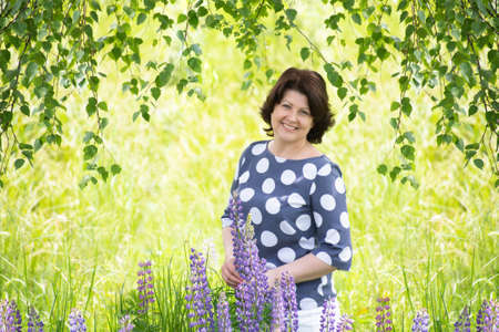 Russian woman near the birch in the summerの写真素材