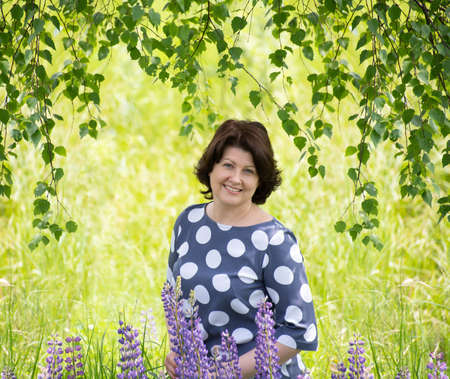 Russian woman near the birch in the summerの写真素材