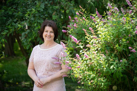 Women in the garden near Pink Buddleyの写真素材