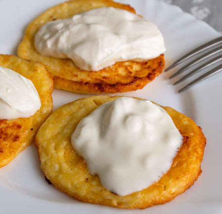 Homemade pancakes with sour cream on a white plateの写真素材