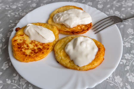 Homemade pancakes with sour cream on a white plateの写真素材