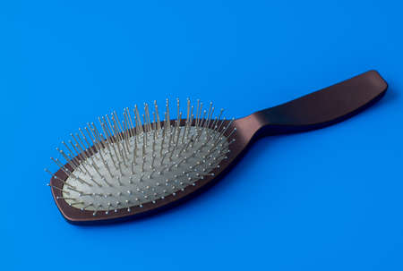The massage comb with metal teeth on a blue backgroundの写真素材