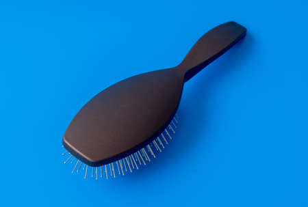 The massage comb with metal teeth on a blue backgroundの写真素材