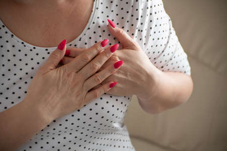 the woman put her hands on the heart area. Heartacheの写真素材
