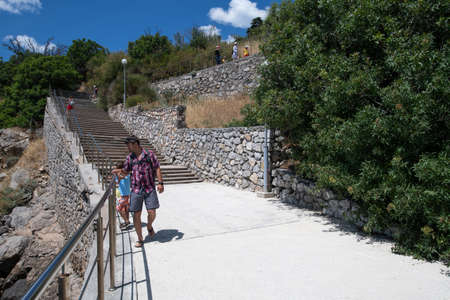 Foros, Crimea - June 30. 2019 Tourists walk the stairs on the embankment