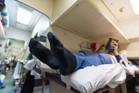 Male legs in black socks in the aisle of a train carの写真素材