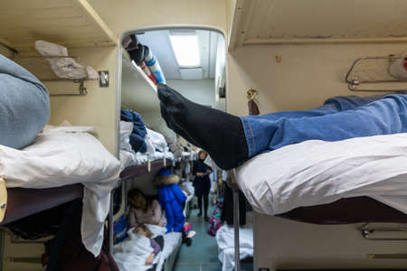 Male legs in black socks in the aisle of a train carの写真素材
