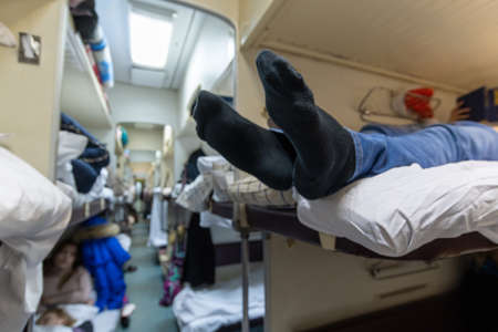 Male legs in black socks in the aisle of a train carの写真素材
