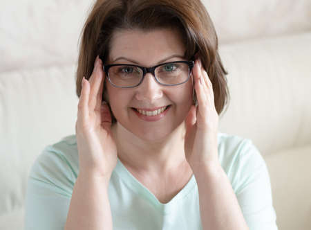 Portrait of a woman with glasses in home interiorの写真素材