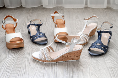 White and blue women's leather sandals stand on floor in the roomの写真素材