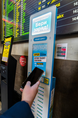 Moscow, Russia - Feb 20. 20201. Hand with a phone on background of charger with powerbank at Kazansky terminusのeditorial素材