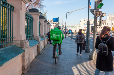 Moscow, Russia - Okt 15. 2021. Delivery club worker rides his bike on a Sretenka Streetのeditorial素材