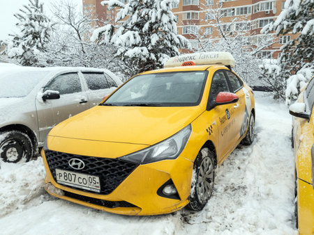 Moscow, Russia - 15.12.2021. Yandex Go car taxi during heavy snowfallのeditorial素材