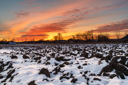 View of beautiful sunset from a snowy fieldの写真素材