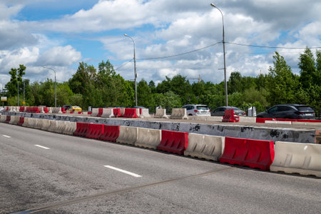 Moscow, Russia - June 04. 2022. Water-filled barriers stand along the road during repairs.のeditorial素材
