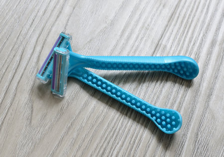 Women's blue razor lies on a wooden backgroundの写真素材