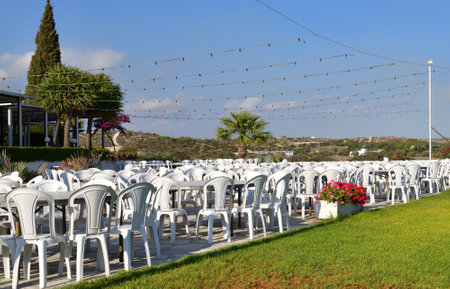 Outdoor cafe with white plastic tables and a chairsの写真素材