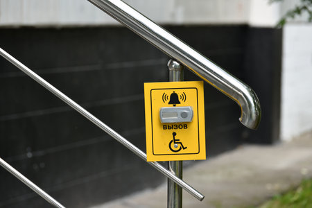 Button for calling help for the disabled on the handrail of the stairsの写真素材