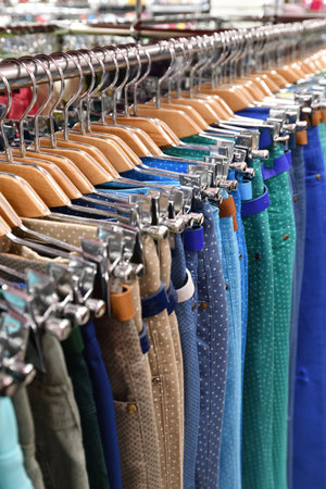 Women's trousers hang in row in a storeの写真素材