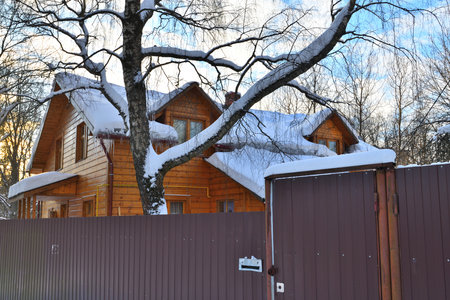 Wooden house in the snow behind fence, Russiaの写真素材