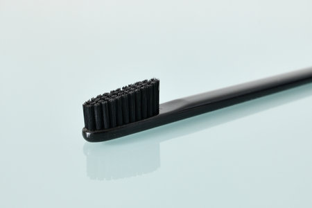 Black Toothbrush on light blue backgroundの写真素材