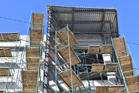 brick monolithic building under construction with wooden scaffoldingの写真素材
