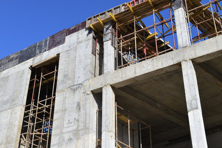 brick monolithic building under construction with wooden scaffoldingの写真素材