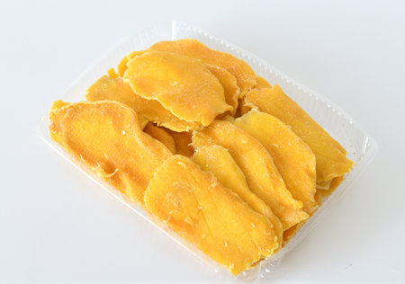 Dry mango in plastic container on a light backgroundの写真素材