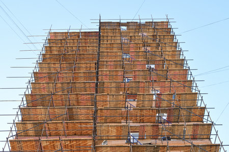 brick house under construction with wooden scaffoldingの写真素材