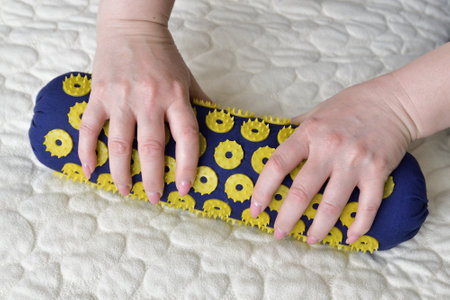 Women's palms on needle roller - foot massage using an applicatorの写真素材