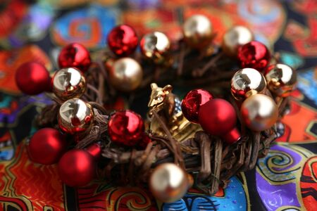 New Year 's wreath of branches and gold and red balls on beige background and rat figureの写真素材