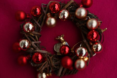 New Year 's wreath of branches and gold and red balls on beige background and rat figureの写真素材